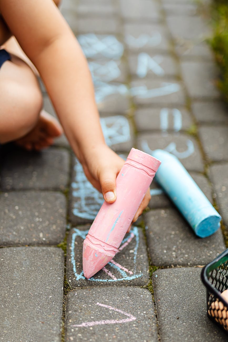 a person writing on the brick floor with a chalk